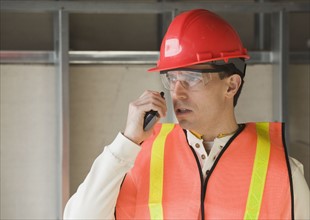 Construction worker talking into cell phone.