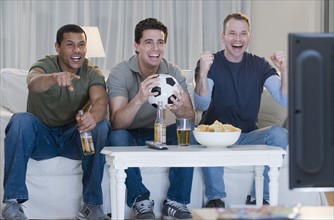 Multi-ethnic men watching sports on television.