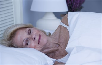 Senior woman sleeping in bed.