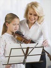Violin teacher and student looking at sheet music.
