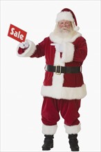 Santa Claus holding Sale sign.
