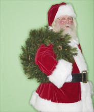 Santa Claus holding wreath.