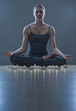 Woman meditating next to candles.