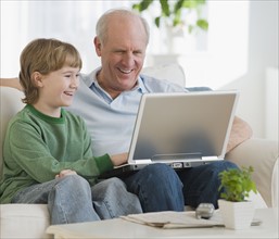 Grandfather and grandson looking at laptop.