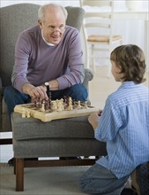 Grandfather and grandson playing chess.