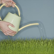 Woman water grass with watering can.