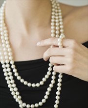 Woman wearing strands of pearls.