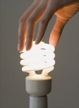 Woman screwing in energy-efficient light bulb.