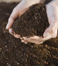 Woman holding handful of soil.