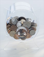 Coins in clear piggy bank.