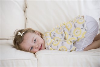 Young girl laying on sofa.
