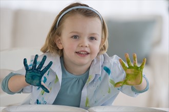 Girl finger painting with different colors.