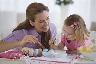 Mother and daughter decorating eggs.