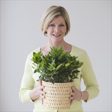 Woman holding potted plant.