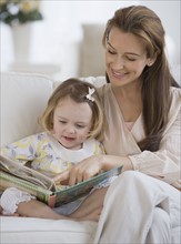 Mother reading to daughter.