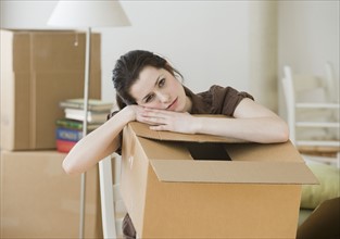 Woman resting on moving box.