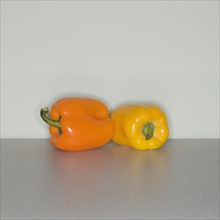 Orange and yellow bell peppers on table.