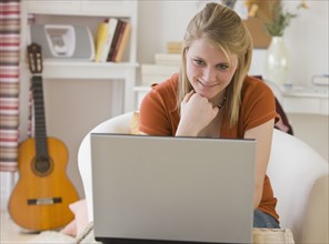 Teenaged girl looking at laptop.