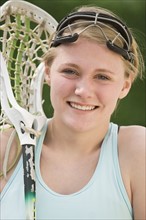 Teenaged girl holding lacrosse racket.