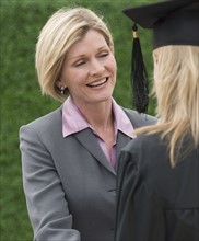 Woman talking to graduate.