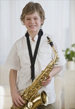 Boy holding saxophone.