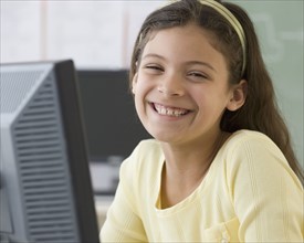 Hispanic girl next to computer.