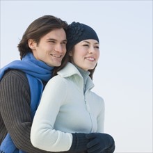 Couple in winter gear hugging.