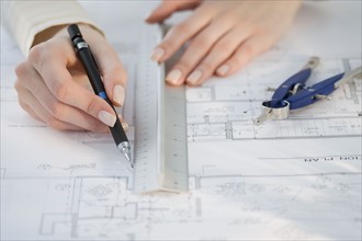 Architect drawing on blueprints.