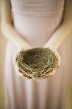 Woman holding bird’s nest.