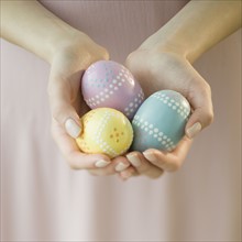 Woman holding decorated eggs.