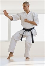 Hispanic male karate black belt in fighting stance.