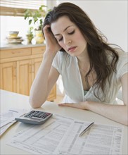 Frustrated woman looking at tax forms.
