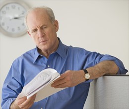 Senior businessman reading paperwork.