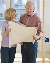 Senior couple looking at blueprints.