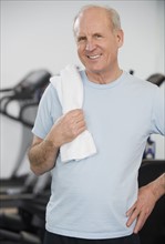 Senior man in front of exercise machines.