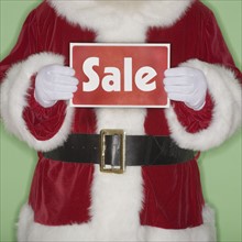 Santa Claus holding Sale sign.