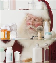 Santa Claus looking in medicine cabinet.