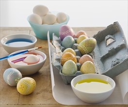 Decorated eggs next to bowls of dye.