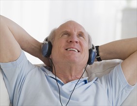 Senior man listening to headphones.