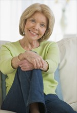 Senior woman sitting on sofa.