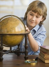 Boy looking at globe.