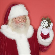 Santa Claus holding alarm clock.