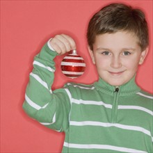 Boy holding Christmas ornament.