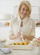 Female baker decorating cake.