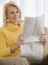 Senior woman reading newspaper.