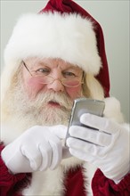 Santa Claus dialing cell phone.