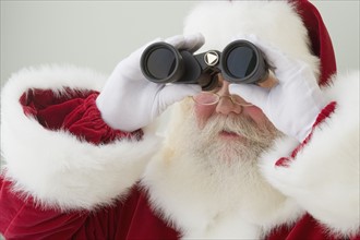 Santa Claus looking through binoculars.