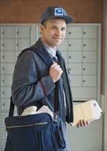 Male postal worker carrying mailbag.