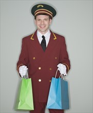 Doorman holding shopping bags.