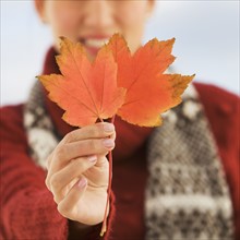 Woman holding autumn leaves.
